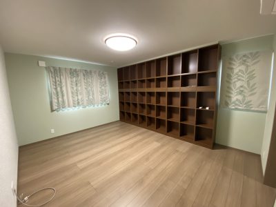 たっぷりの本棚を備えた洋室。リーフ柄のカーテンとグリーン色の壁がしっくり落ち着きます。